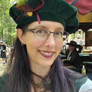 Margaret Boas wearing a green hat with a purple ribbon and green feather