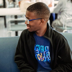 Student sitting inside on a couch.